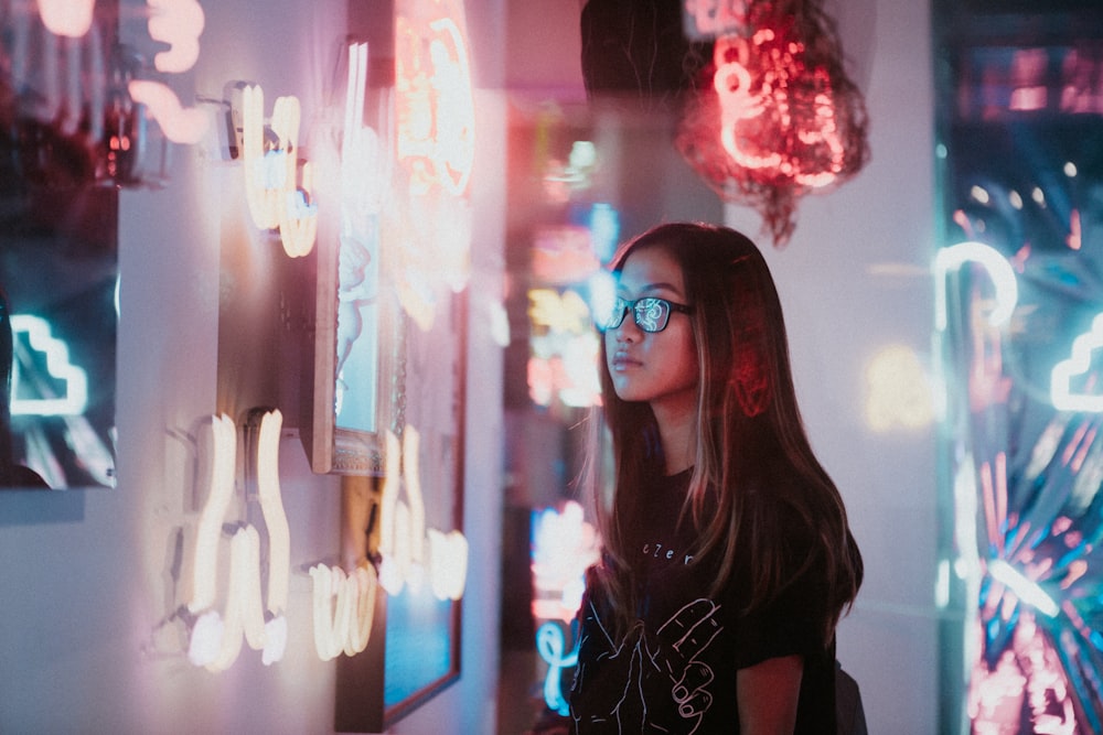 woman standing beside neon signs