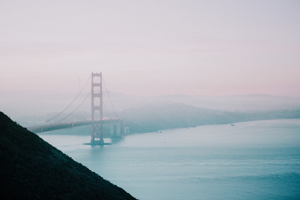 red suspension bridge filled with fog