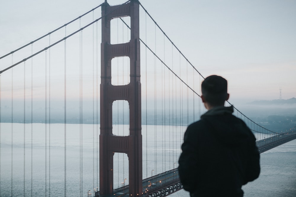 man facing Golden Gate Bridge during daytime