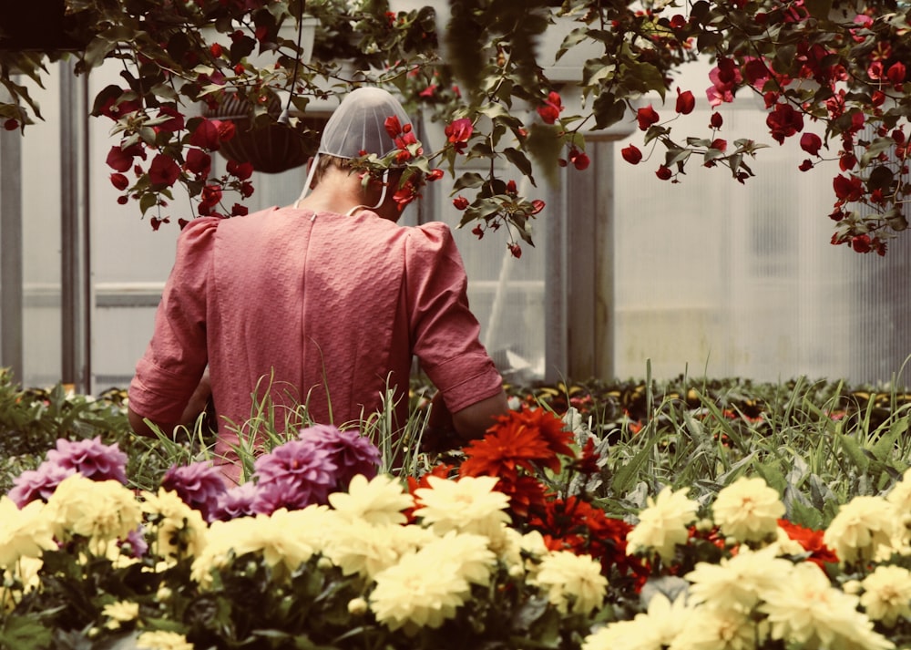 person standing beside flowers