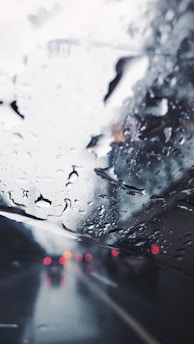 a view of a rain covered windshield from inside a car
