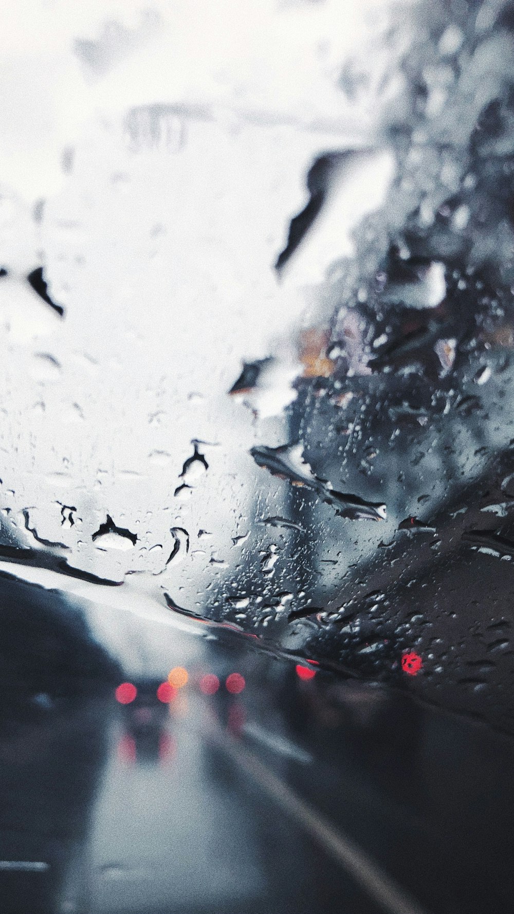 a view of a rain covered windshield from inside a car