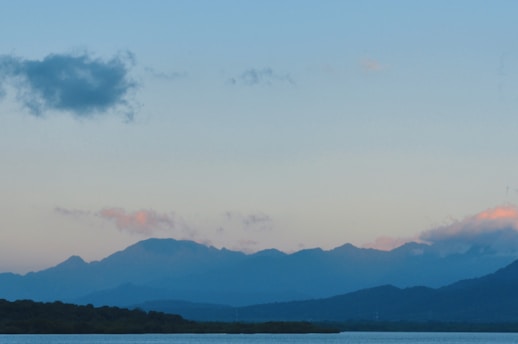 A serene landscape showcasing a mountain range with a clear blue sky.