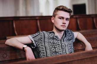 Young man in a wooden pew looking contemplative, symbolizing introspection and the mental health 