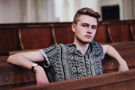Young man in a wooden pew looking contemplative, symbolizing introspection and the mental health 