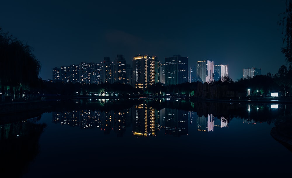 high rise buildings across body of water during nightime
