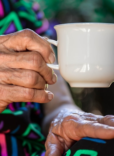 person holding white ceramic teacup