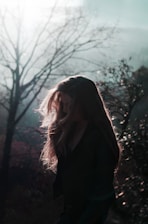 Portrait of Shadowsylph in a dark forest, silver accents glowing softly on black attire.