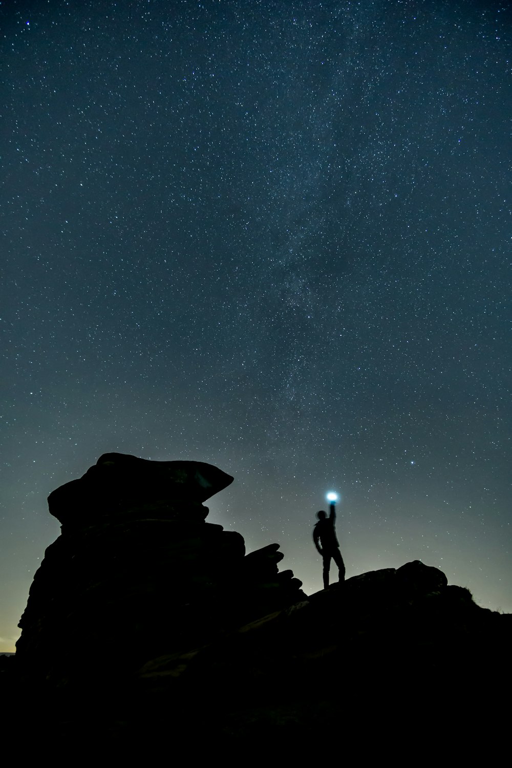 silhouette photo of man at top of mountain