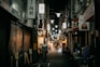 person walking in alley with signs