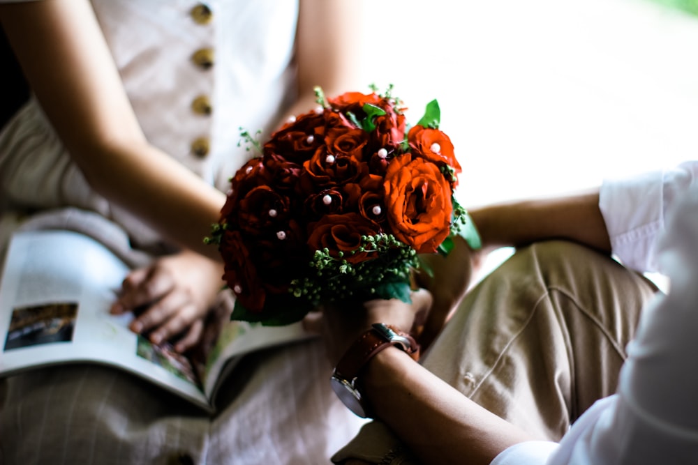 man holding red bouquet of flowers