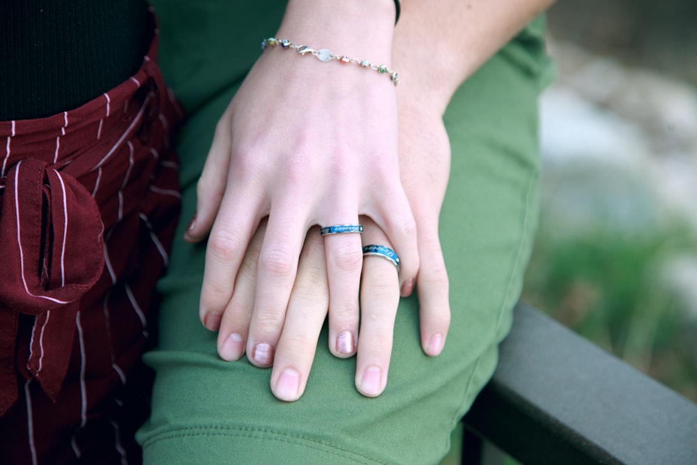 couple holding hands while sitting on bench