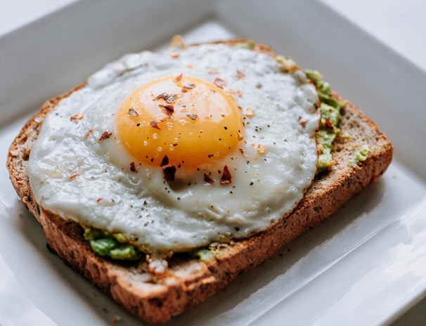 bread with sunny side-up egg served on white ceramic plate