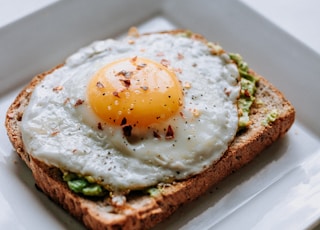 bread with sunny side-up egg served on white ceramic plate