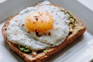 bread with sunny side-up egg served on white ceramic plate