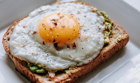 bread with sunny side-up egg served on white ceramic plate