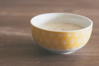 Close-up of a cheerful yellow ceramic bowl with subtle texture and soft natural light.