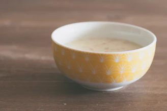Close-up of a cheerful yellow ceramic bowl with subtle texture and soft natural light.