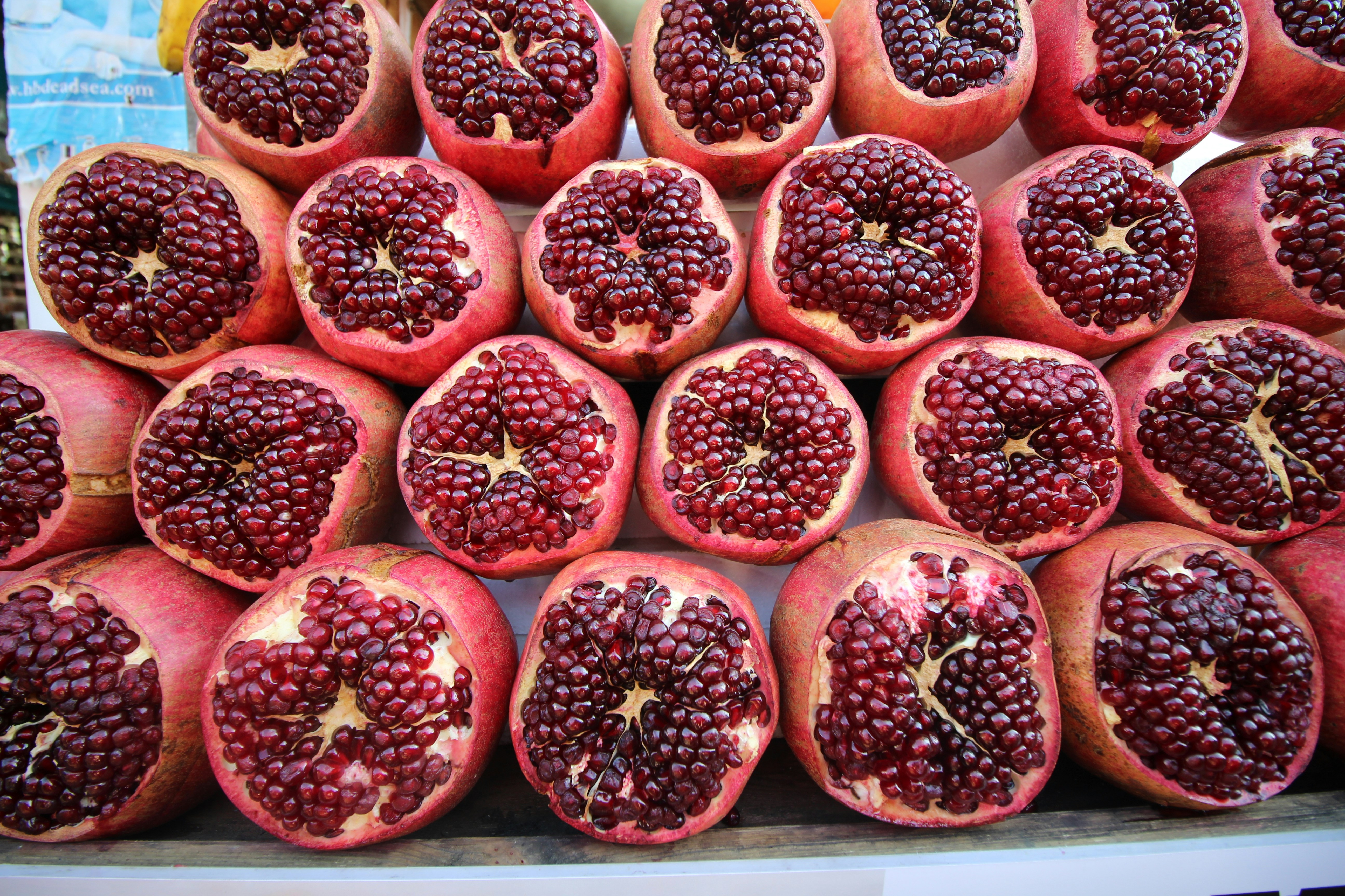 Fresh Afghan pomegranates from Kandahar, whole and open showing ruby-red arils
