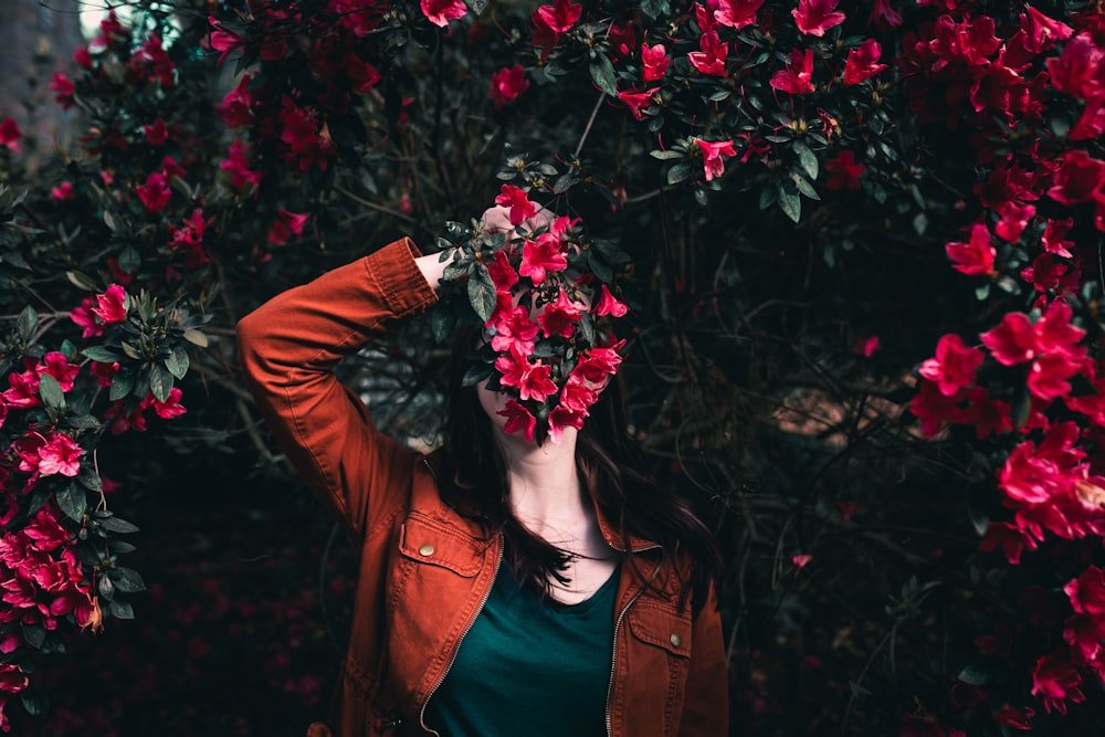 woman holding flower standing near flowers