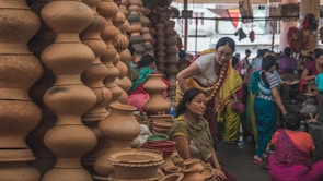 Women gathered around a traditional market stall, admiring colorful local crafts in a vibrant cultural destination.