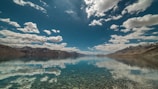 The tranquil Humantay lagoon reflecting the blue sky and mountain peaks in the distance