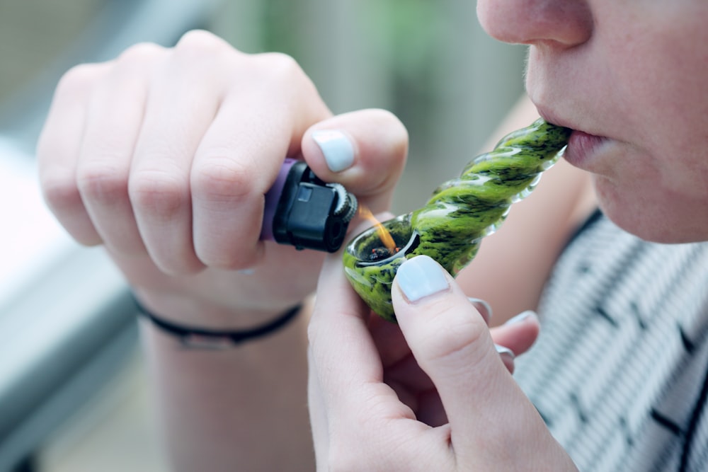 person holding lighting spoon pipe