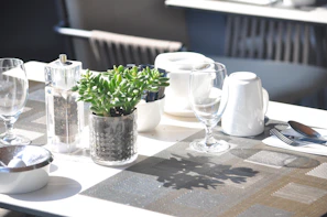 A bright, inviting table setting featuring spalvota širdis ceramics in natural light.