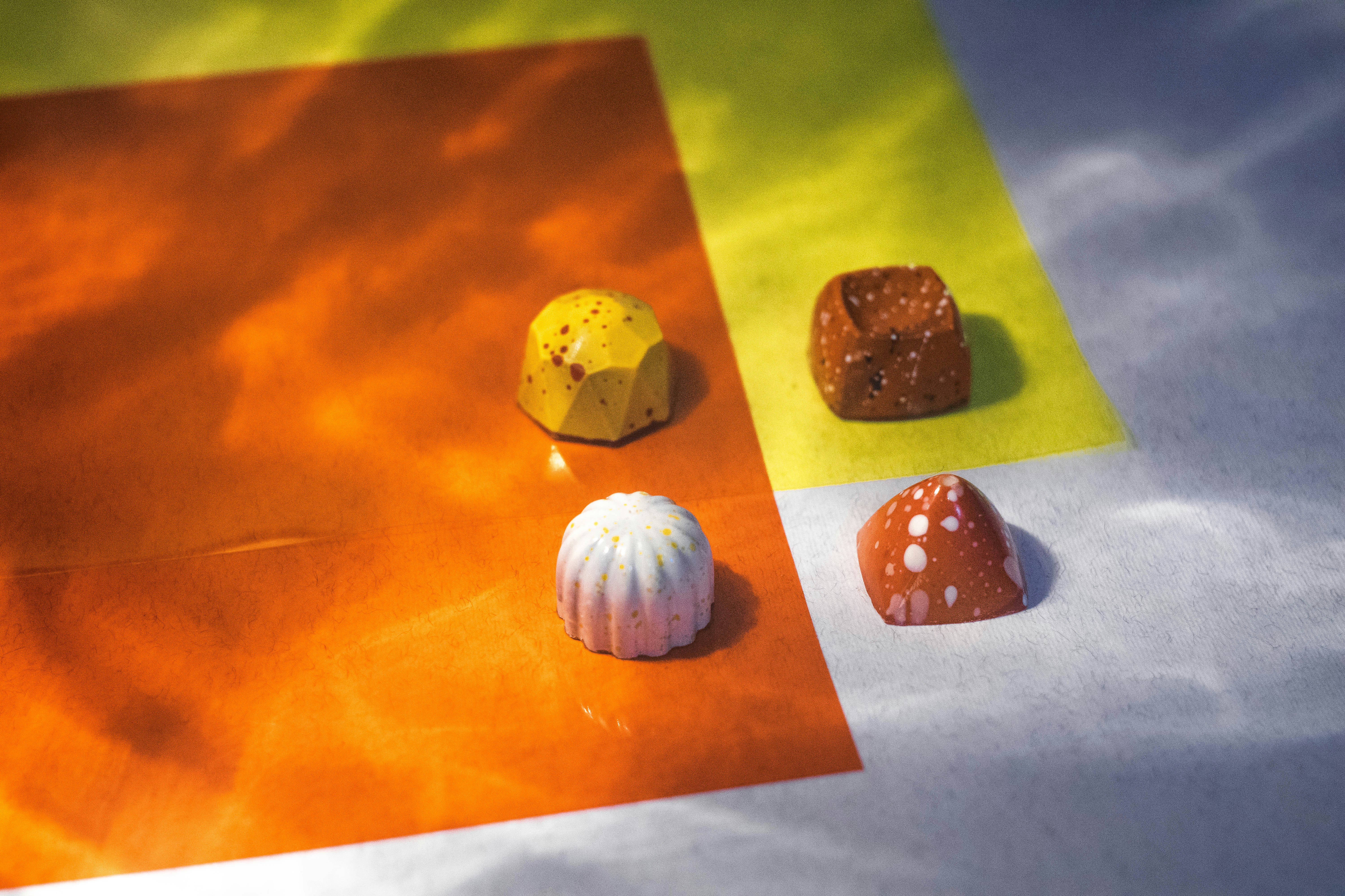 Assorted artisan chocolates with different fillings on dark background