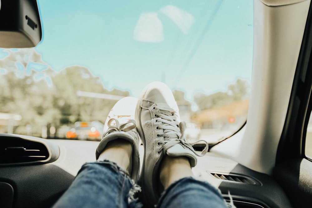 person resting feet on car dashboard
