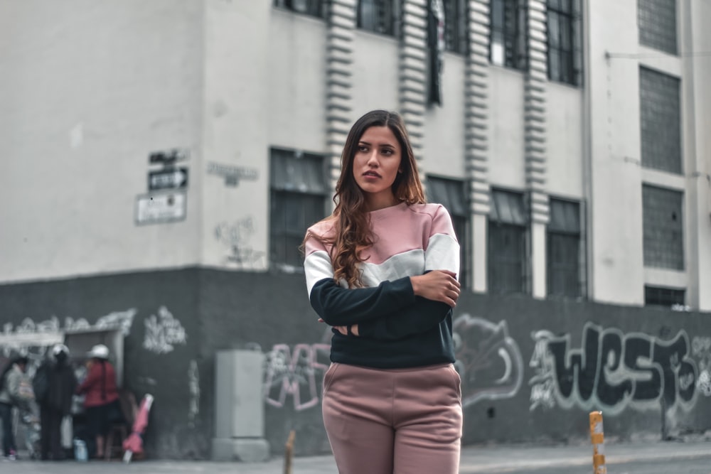 woman standing beside black and gray concrete building