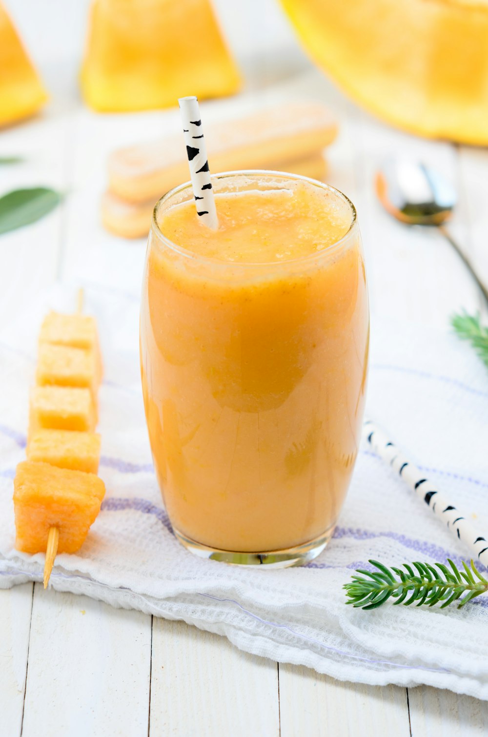 yellow fruit juice on glass cup