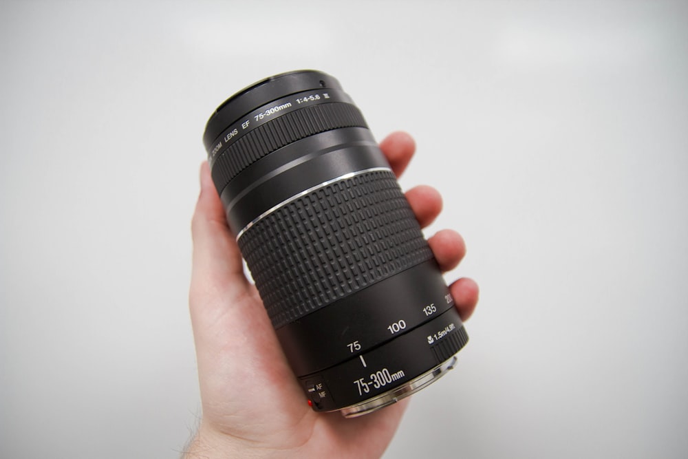 黒のニコン75-300mmカメラレンズをhplding人