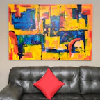 Modern artwork hanging above sofa in bright loft room