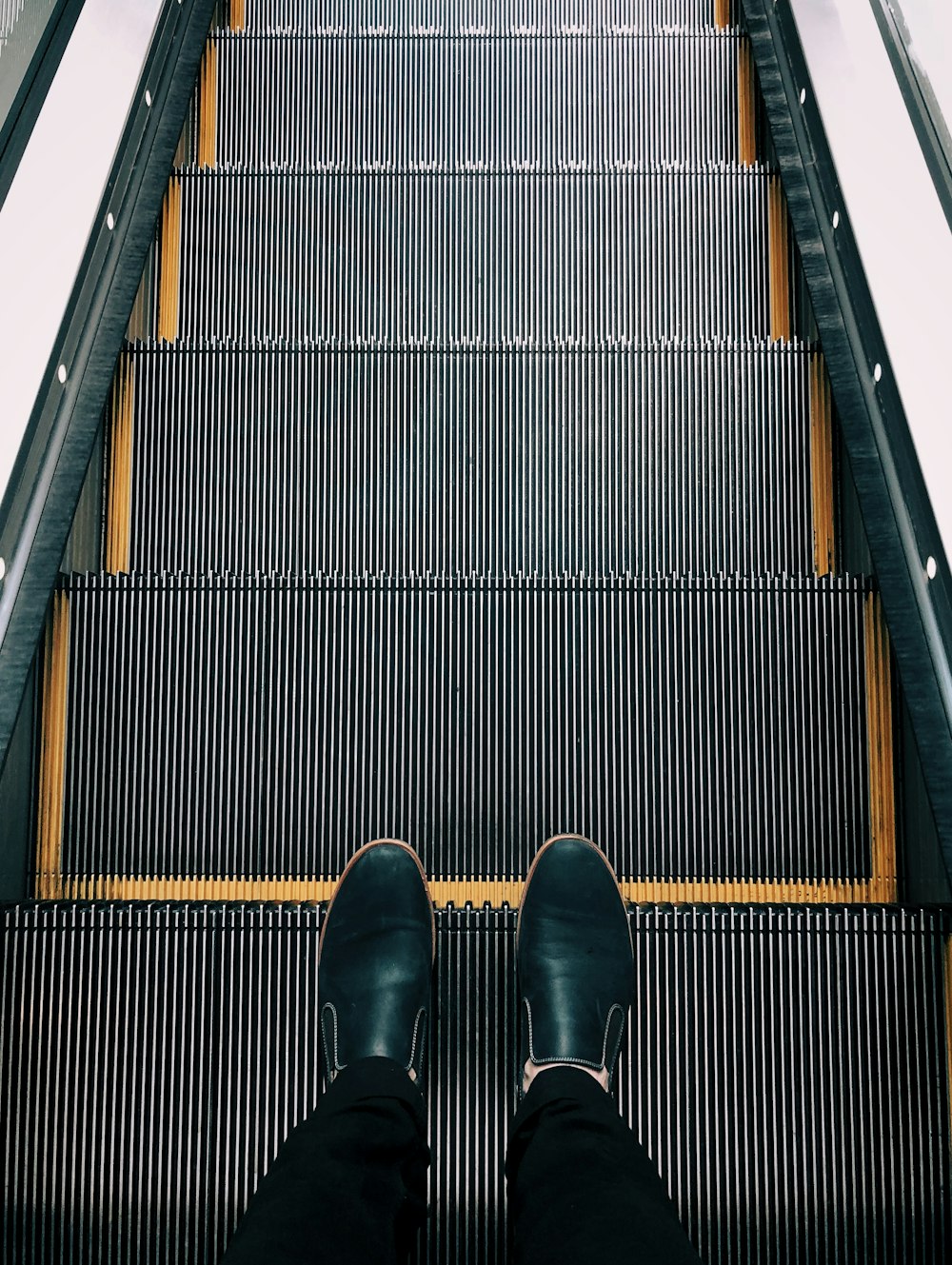 person standing on escalator