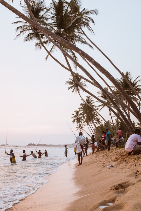 group of people standing in sea shore in Unawatuna Sri Lanka