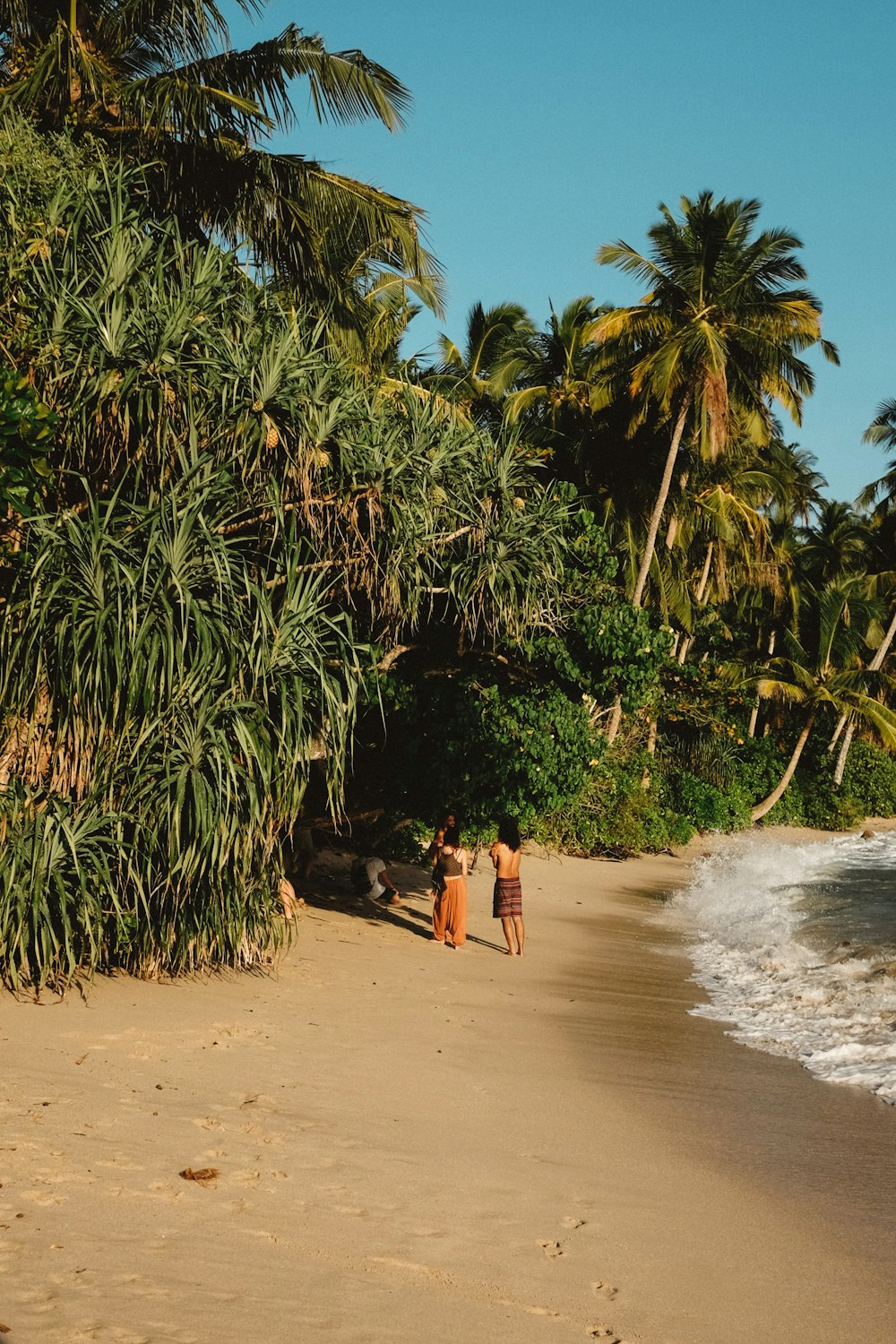 three persons standing near sea at daytime