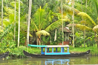 A colorful traditional boat sailing near a tropical island shore
