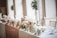 A beautifully arranged wedding table setting with elegant floral centerpieces and soft lighting.