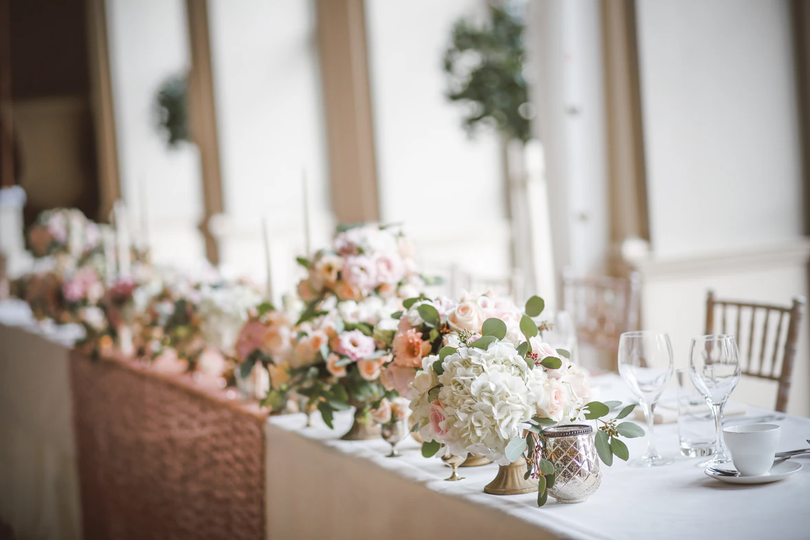 Elegant table setting with floral arrangements and candles ready for a wedding reception