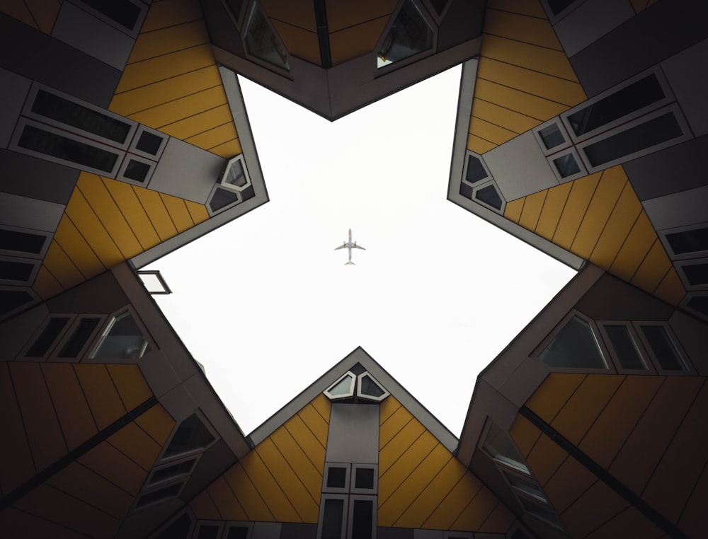 Wurmperspektive auf ein Gebäude, das ein Flugzeug am Himmel zeigt