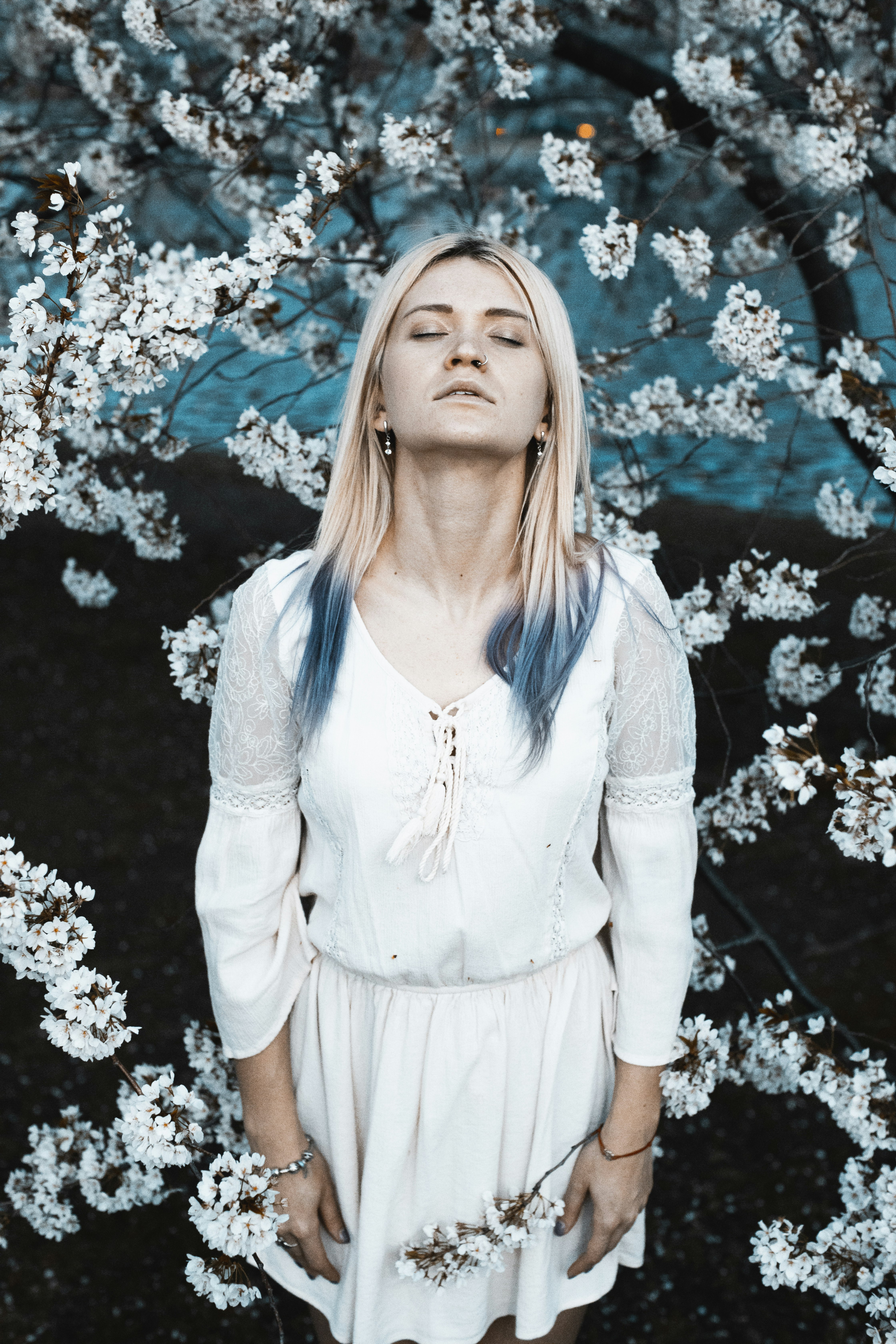 woman standing on brown soil surrounded by white flowers during daytime