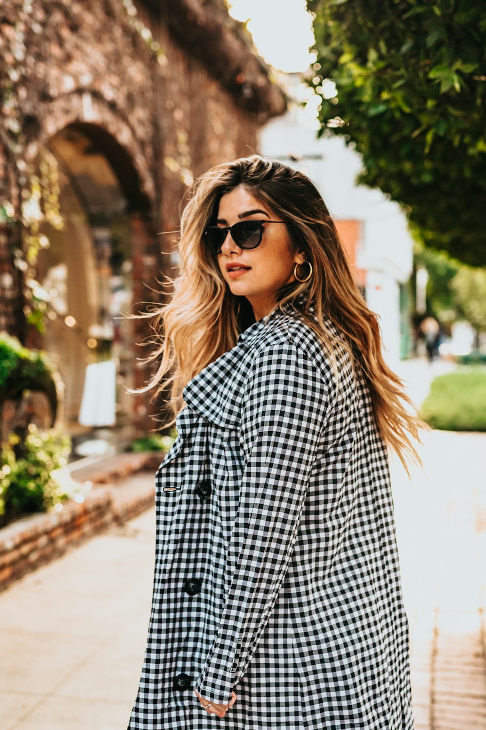 Mujer posando para la foto cerca de un edificio de hormigón durante el día