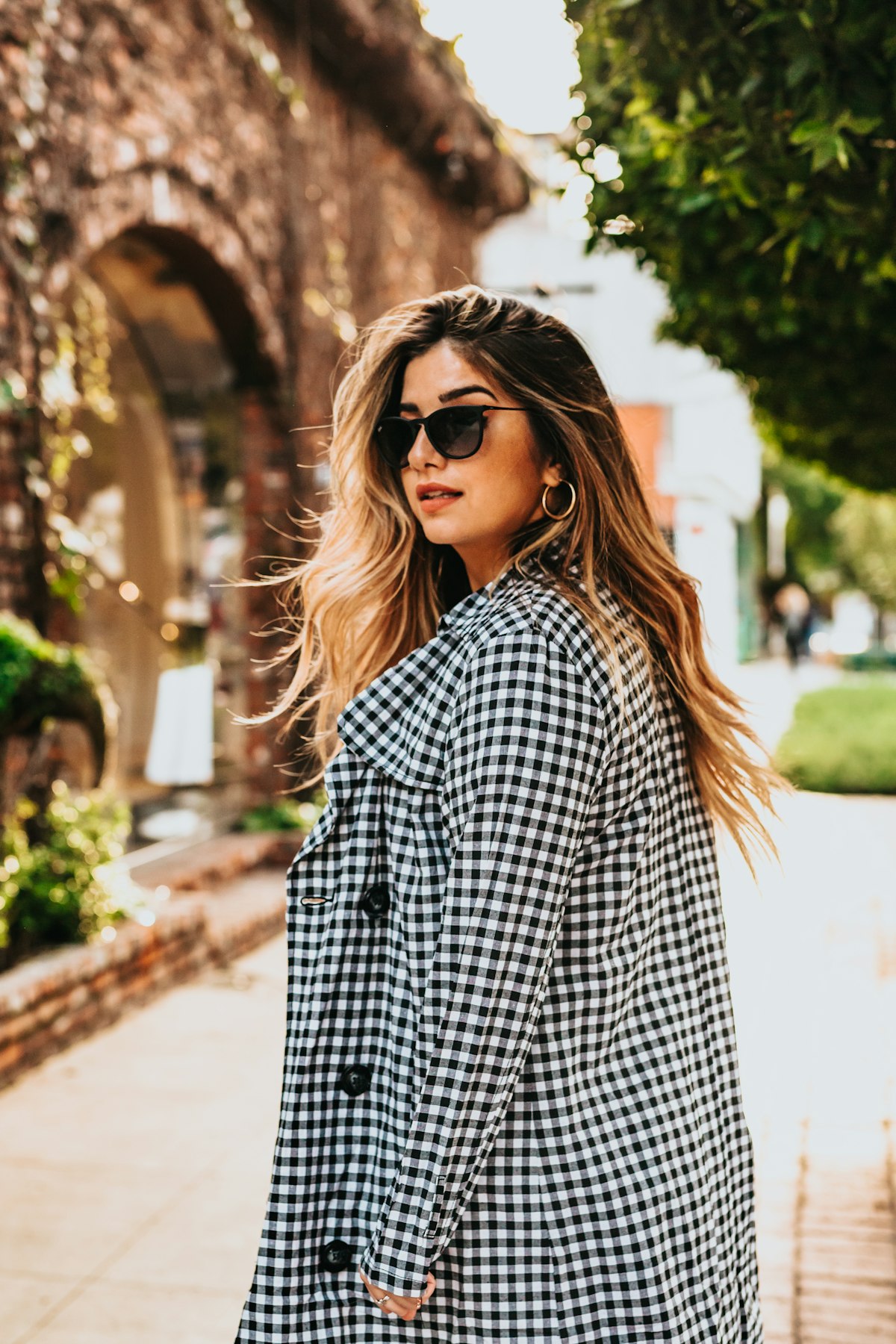 Woman in a tailored gingham jacket walking away