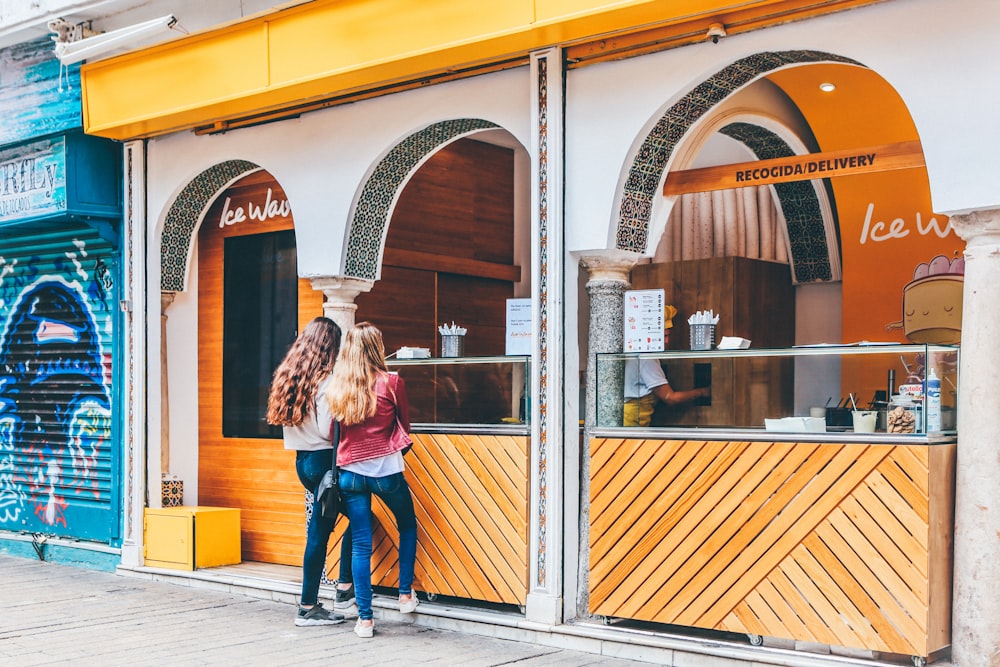 deux femme debout devant le stand de nourriture