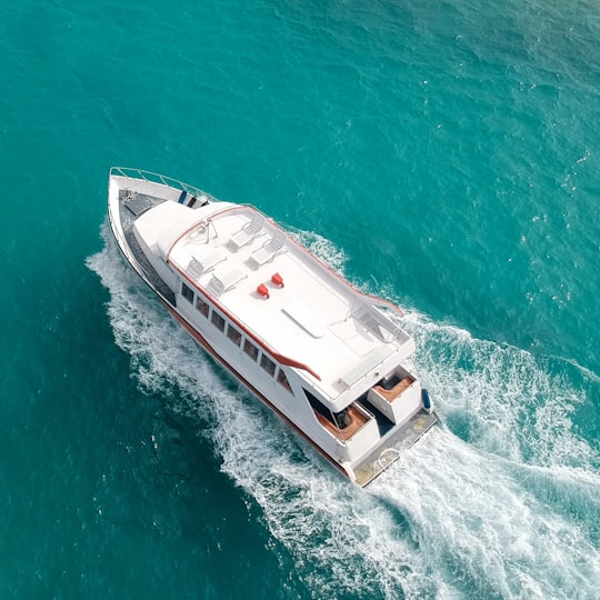 aerial photo of white and brown yacht on water in Thinadhoo Maldives