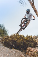 A rider performing a jump over a rocky terrain.