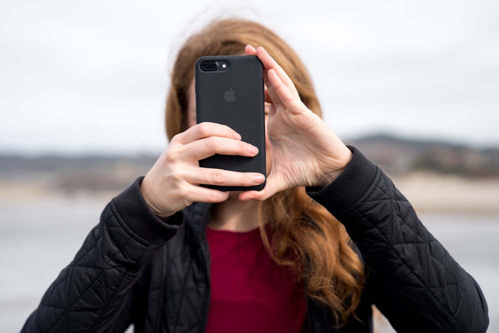 mujer tomando foto con iPhone 8 Plus negro