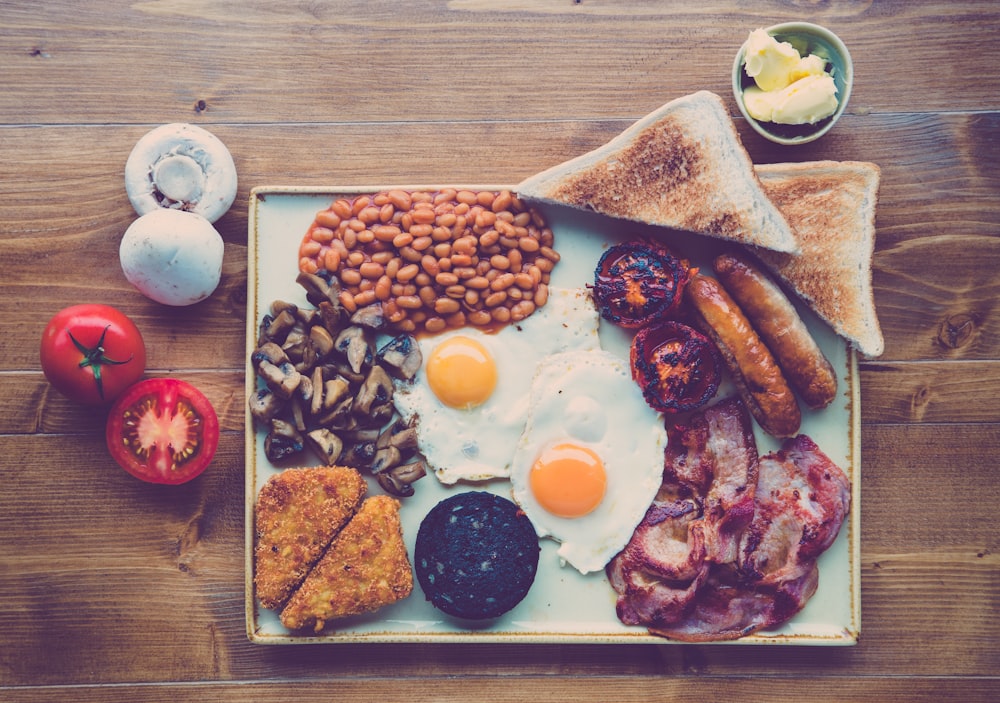 fried ham, egg, bread with beans and red tomato slice