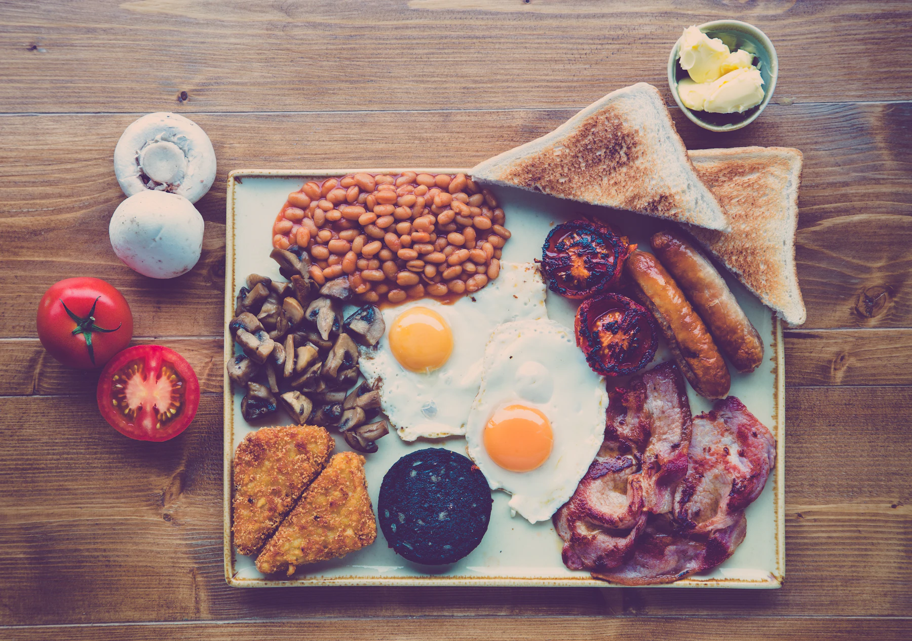 A full cooked breakfast with eggs, sausages, bacon, beans and toast